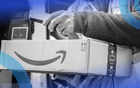 A delivery person is holding an Amazon package.