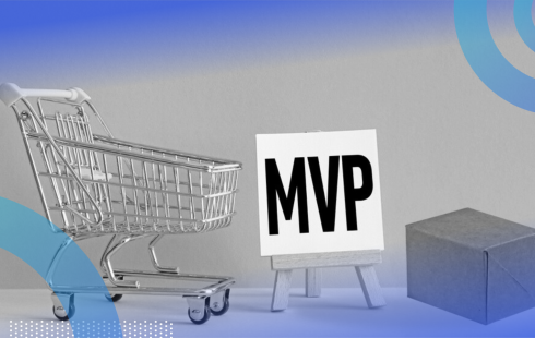 A shopping cart, a white sign on an easel with “MVP” written on the canvas in black block letters and a plain cardboard box.