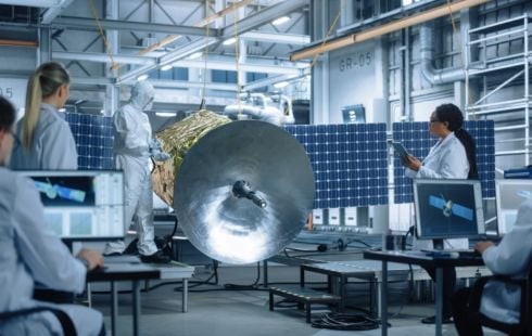 Engineers work on a satellite.