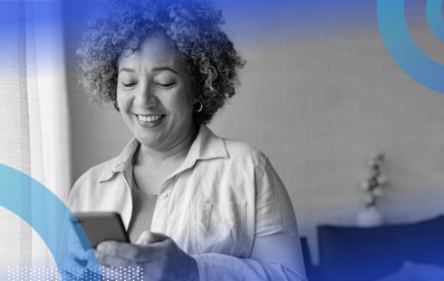 A woman smiling at her smart phone.