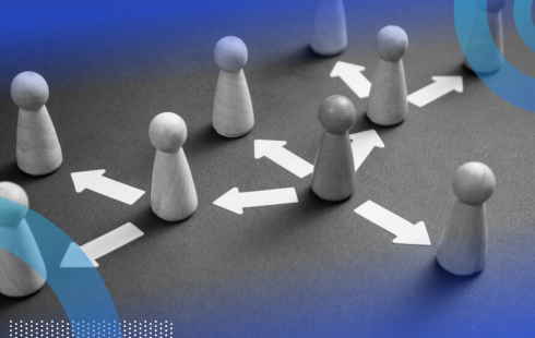 Eight wooden people figures, one a darker color than the rest, with arrows pointing from one figure to the next, indicating work delegation.