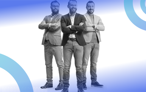 Three smiling white men are standing with their arms crossed over their chests.