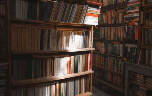 books on library shelves with light shining down on them