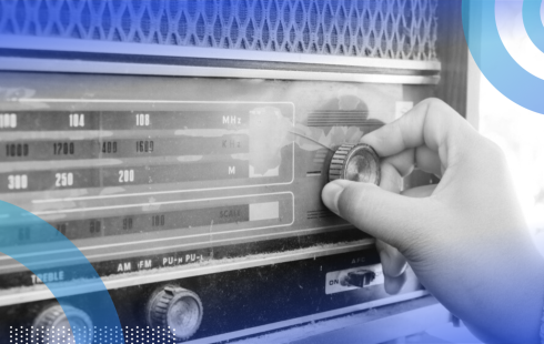 A close-up of a hand tuning an old-fashioned stereo.