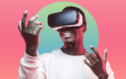 A man wearing a VR headset, holding his hands out.