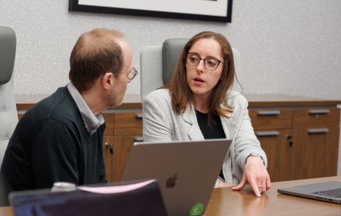 Two Prosodica employees exchange ideas in a conference room.
