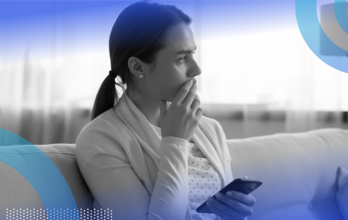 A woman holds a smartphone and looks worried