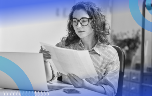 A woman software developer with glasses looks at documentation