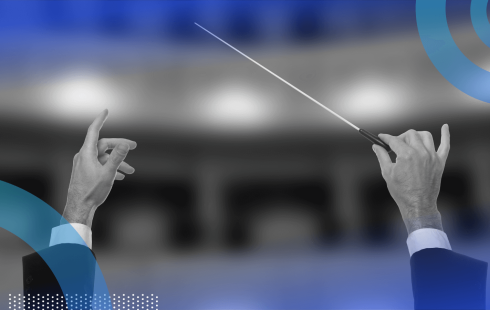 A condutor holds a baton aloft in a theatre