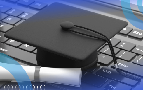 A degree and graduation cap lying on a keyboard