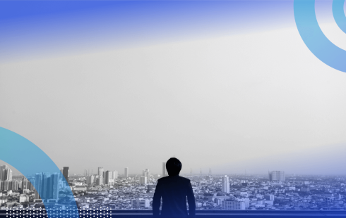 A person looks out from a balcony on a cityscape
