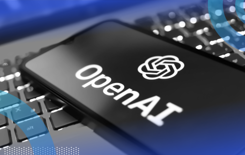 A smartphone with the OpenAI logo on top of a laptop keyboard
