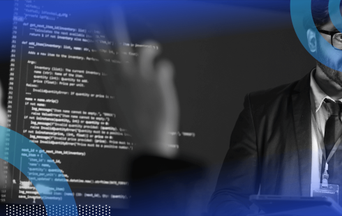 A woman asks a question of an engineer in front of a screen displaying code