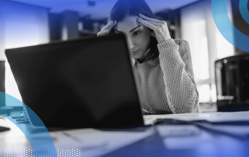 A woman looks frustrated while working on her laptop