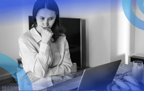 A young woman looks at a laptop with an expression of concern