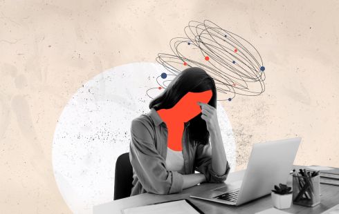 A person working on their laptop with a red face, as if they are experiencing frustration