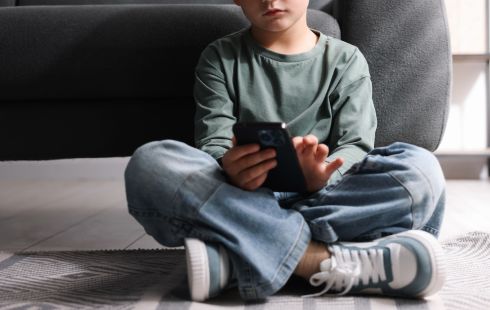 A child uses social media on a smartphone.