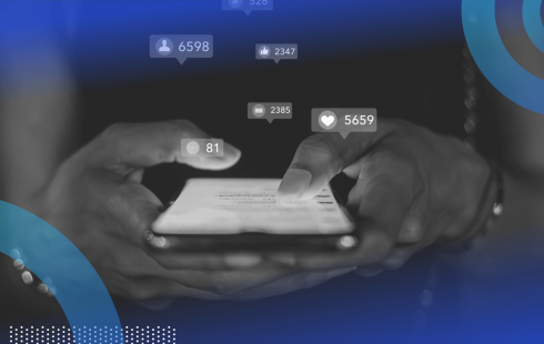 A closeup on someone holding a smartphone with social media reaction icons