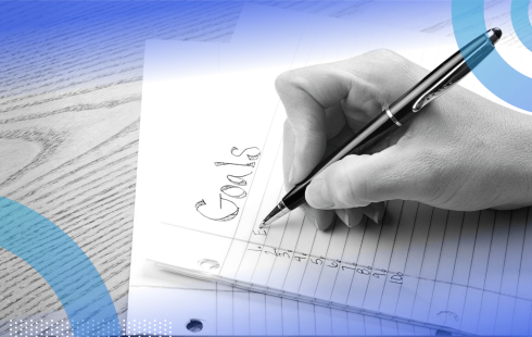 A closeup on a hand writing a list of goals