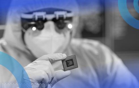 A researcher in a clean suit holds a semiconductor