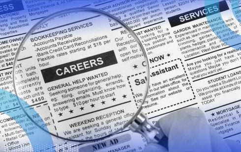 A magnifying glass over a newspaper classified ad