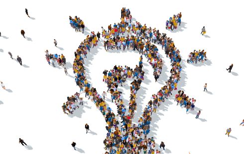 An illustration of people standing in the shape of a lightbulb to show the idea of working together on tech that impacts people and new ideas. 