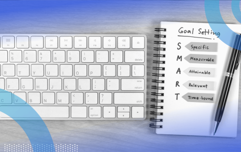 A notepad with a definition of "SMART goals" next to a keyboard