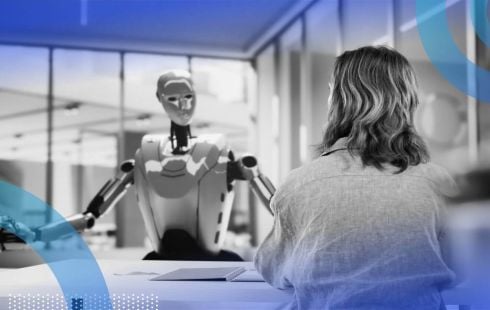 A robot talks to a woman across a desk