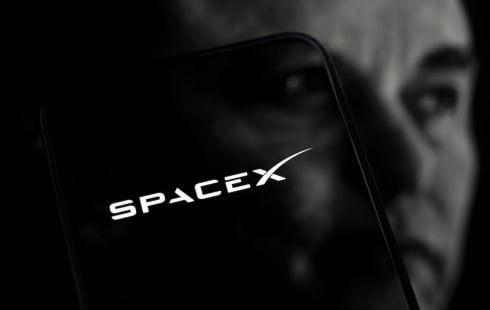 The SpaceX logo superpositioned over the face of CEO Elon Musk.