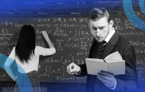 A man reads from a book while a woman does math on a chalkboard