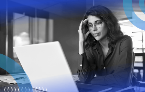 A woman looks at her laptop with frustration.