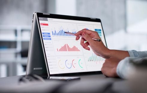 A hand uses a pen to point to a visualization on a big data analytics tool.