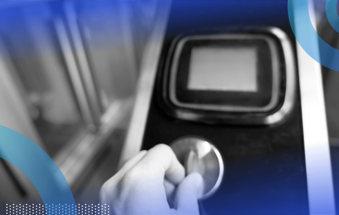 A hand puts a token into a subway turnstile coin slot