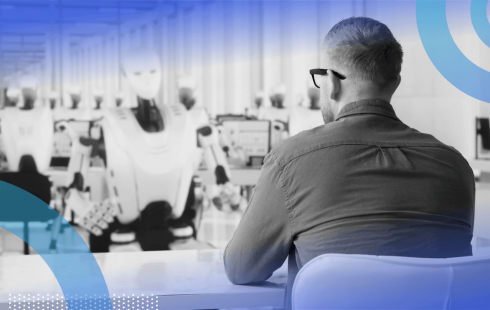 A man sits across a desk from a robot