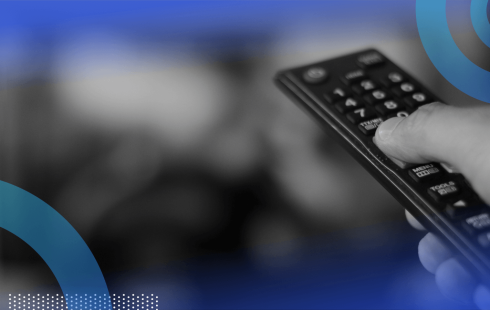 A hand points a remote at the TV