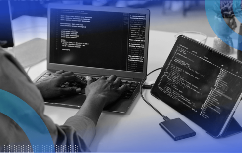 A developer works on code on a laptop and a tablet