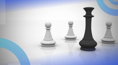 A black queen chess piece stands in front of three white pawn chess pieces. /career-development/when-how-develop-influence