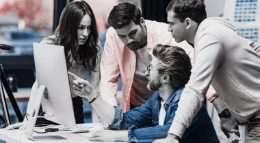 a group surrounding a computer to represent an art director leading visual design