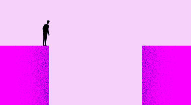 A person standing on one endo of a large gap looking down into it.