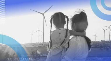 A woman and little girl look at wind turbines