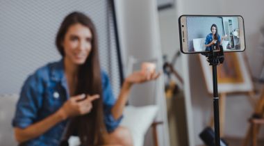 An influencer films video content using a smartphone.