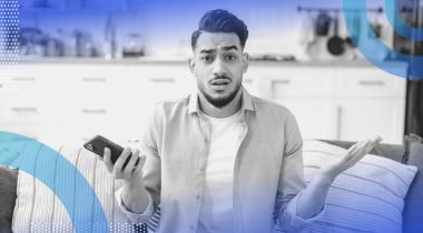 A person holding a phone and looking confused. Voice cloning copies human voices with alarming accuracy.