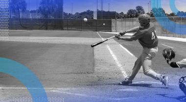 A baseball player swinging at a ball on a baseball field with a catcher behind him.