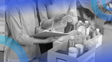 Two people from the neck-down sorting items into donation boxes. One is holding a water bottle and the other is holding a clipboard and pen.
