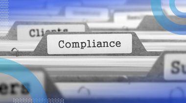 A close-up of files in a filing cabinet, with the file in focus labeled “compliance.”