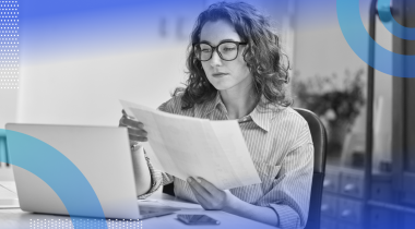 A woman software developer with glasses looks at documentation