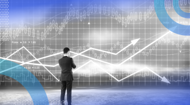 A man in a suit ponders graph trend lines