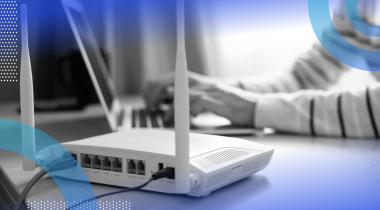 A picture of a cable modem next to a laptop.