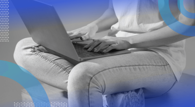 A software engineer works with a laptop on their lap