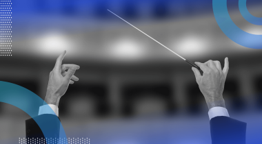 A condutor holds a baton aloft in a theatre